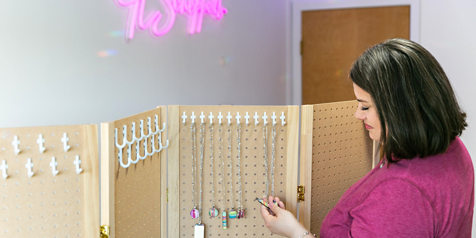 Jamie Scheppers in her home office taking inventory of hand-painted watercolor necklaces.