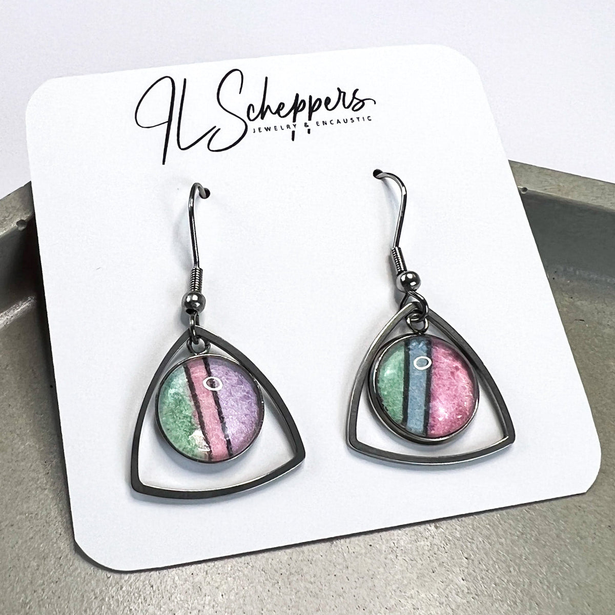 Pink, green, blue and purple pastel watercolor earrings shown on earring card. 