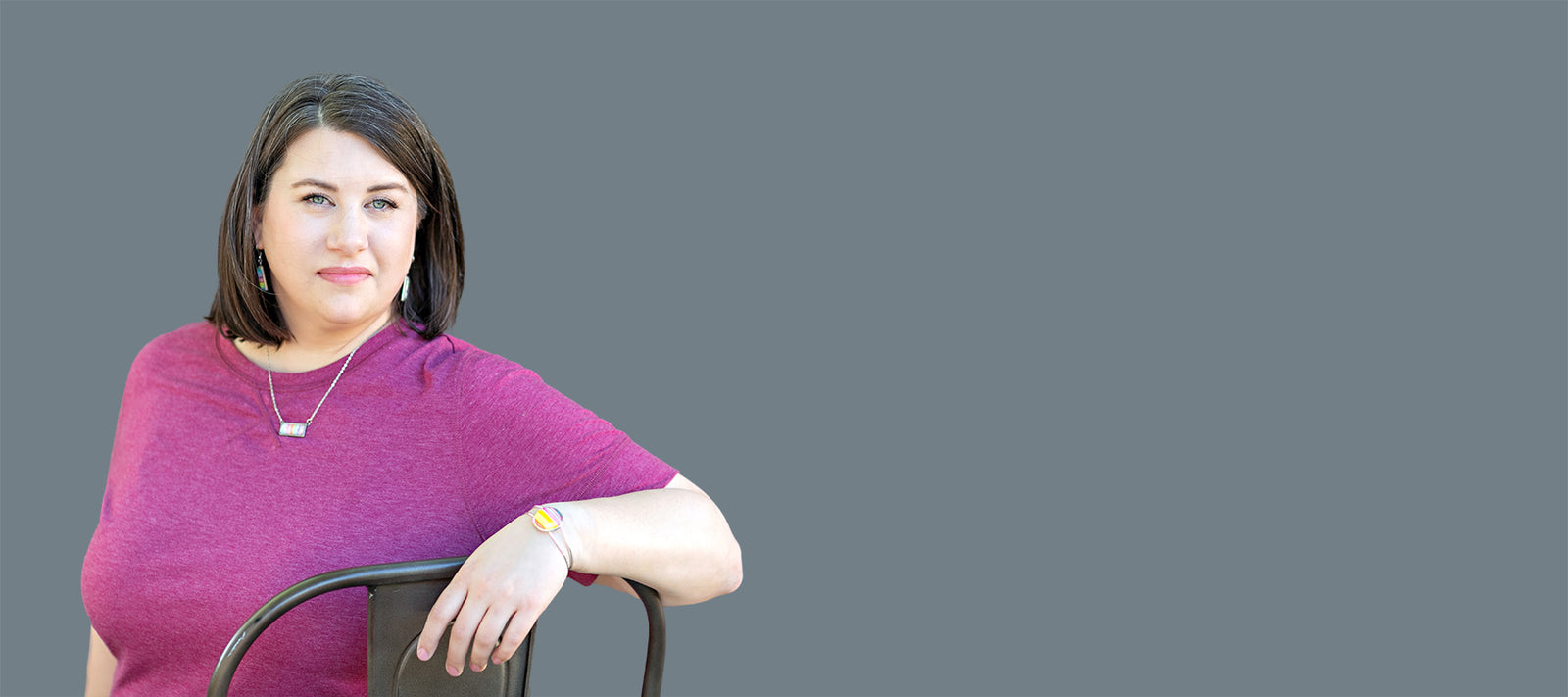 Jamie Scheppers sitting in a chair with a grey background. 