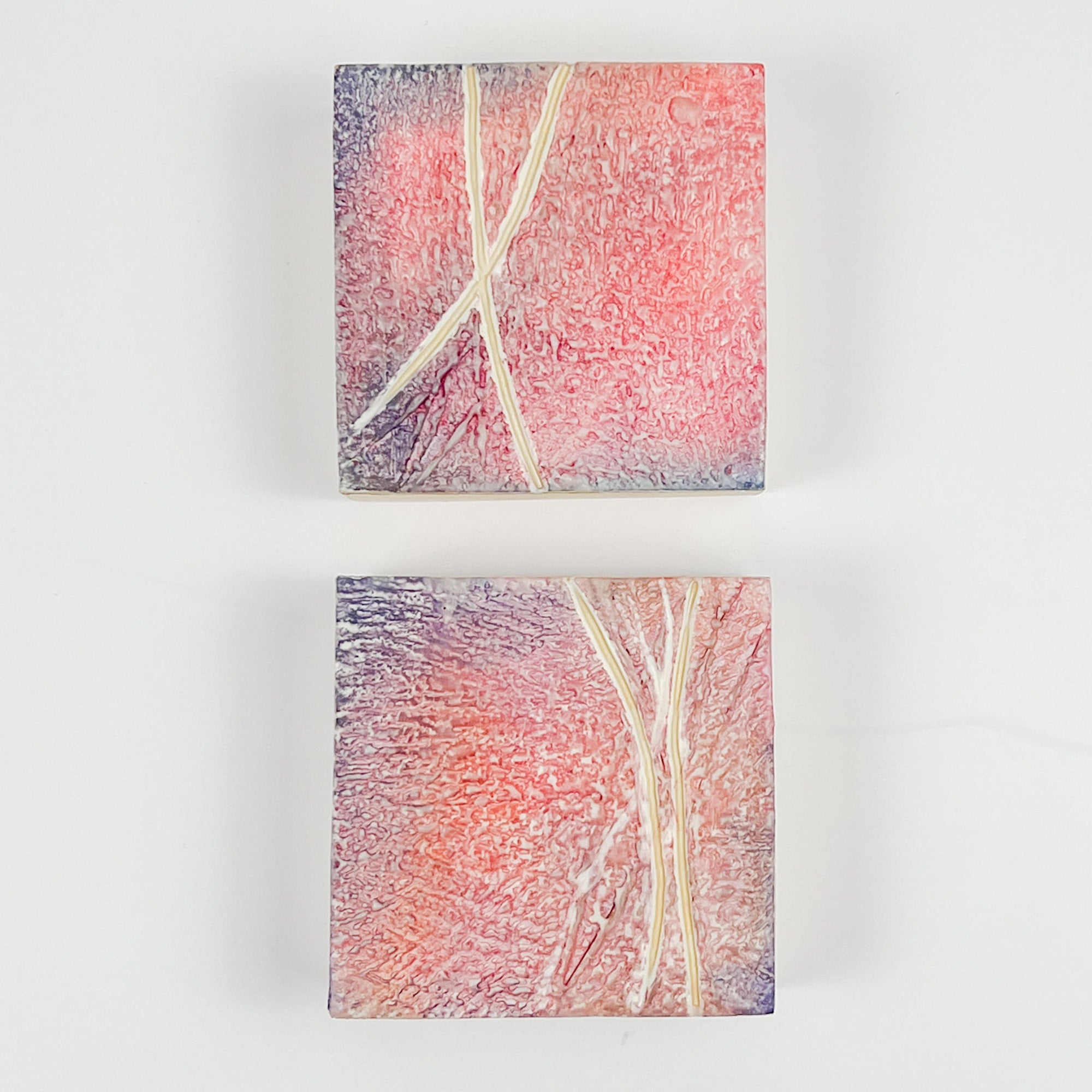 Two pink and purple textured encaustic paintings measuring 4" x 4" 