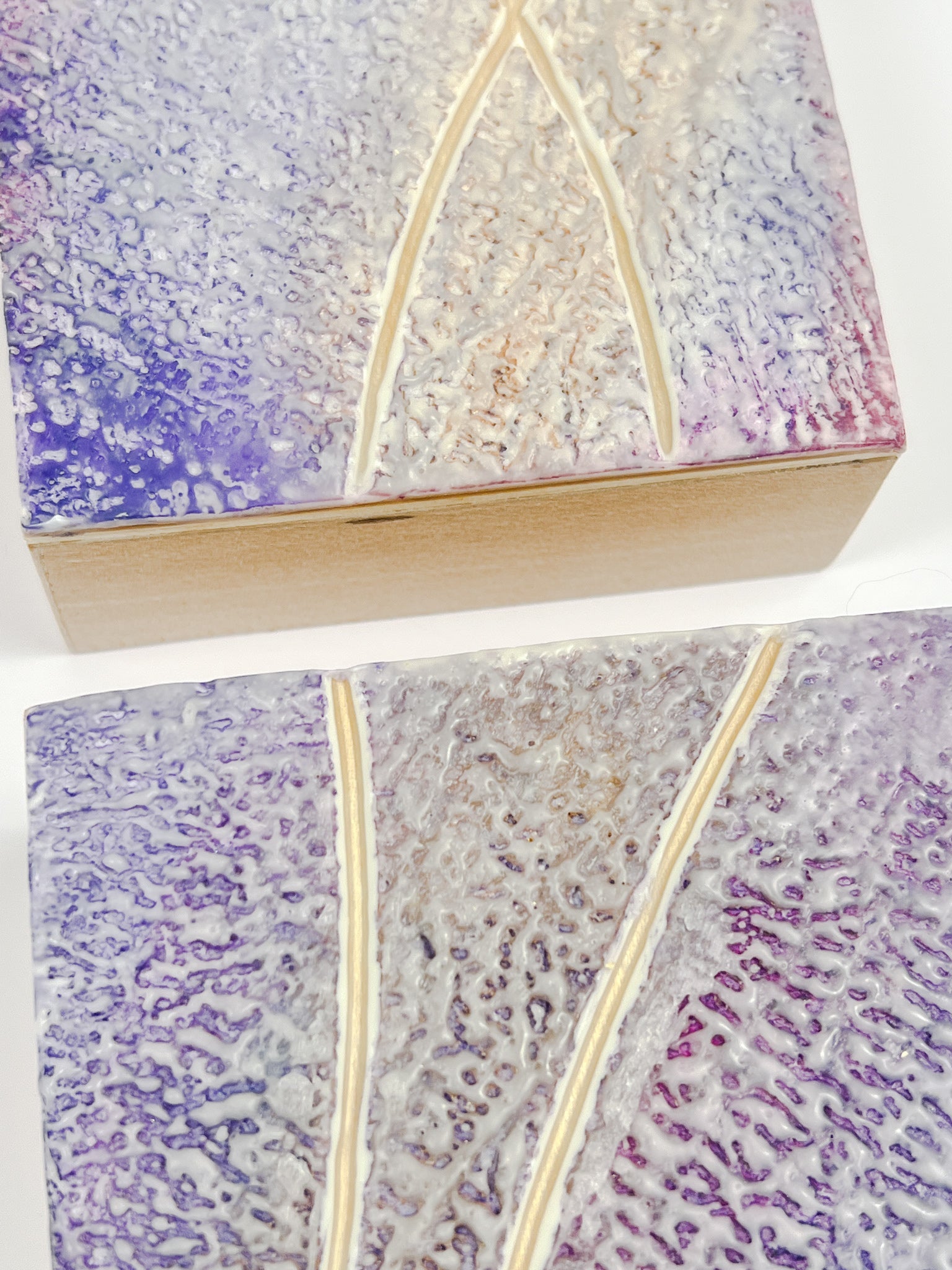 Close up of showing the edges of the cradledTwo purple textured encaustic paintings measuring 4" x 4"