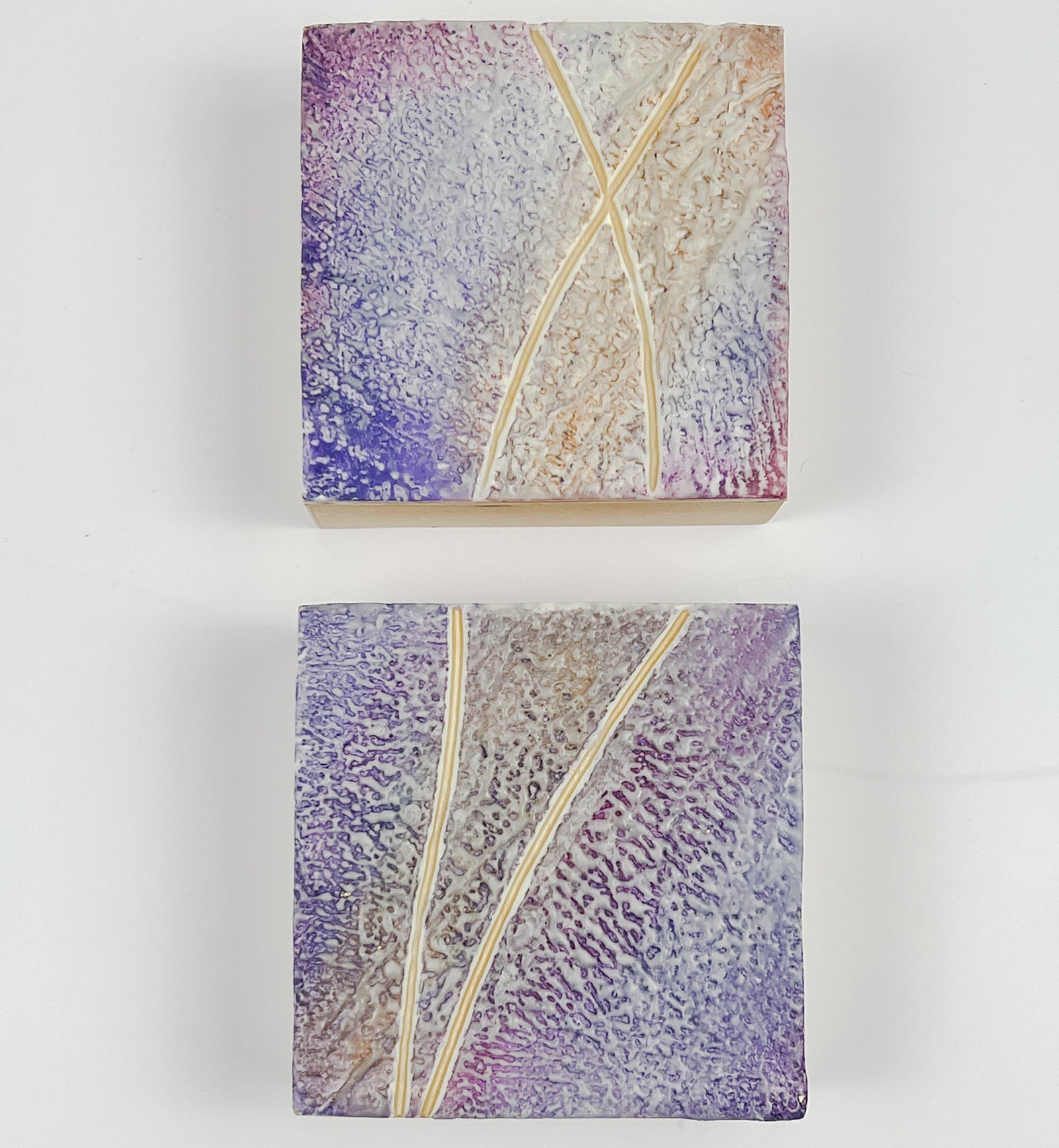 Close up of showing the edges of the cradledTwo purple textured encaustic paintings measuring 4" x 4"
