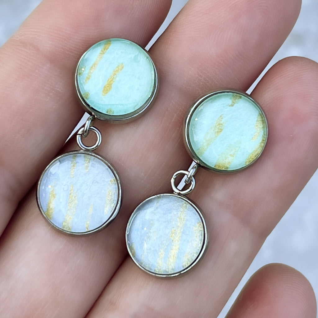 Phoebe earrings shown in the hand for scale. 
