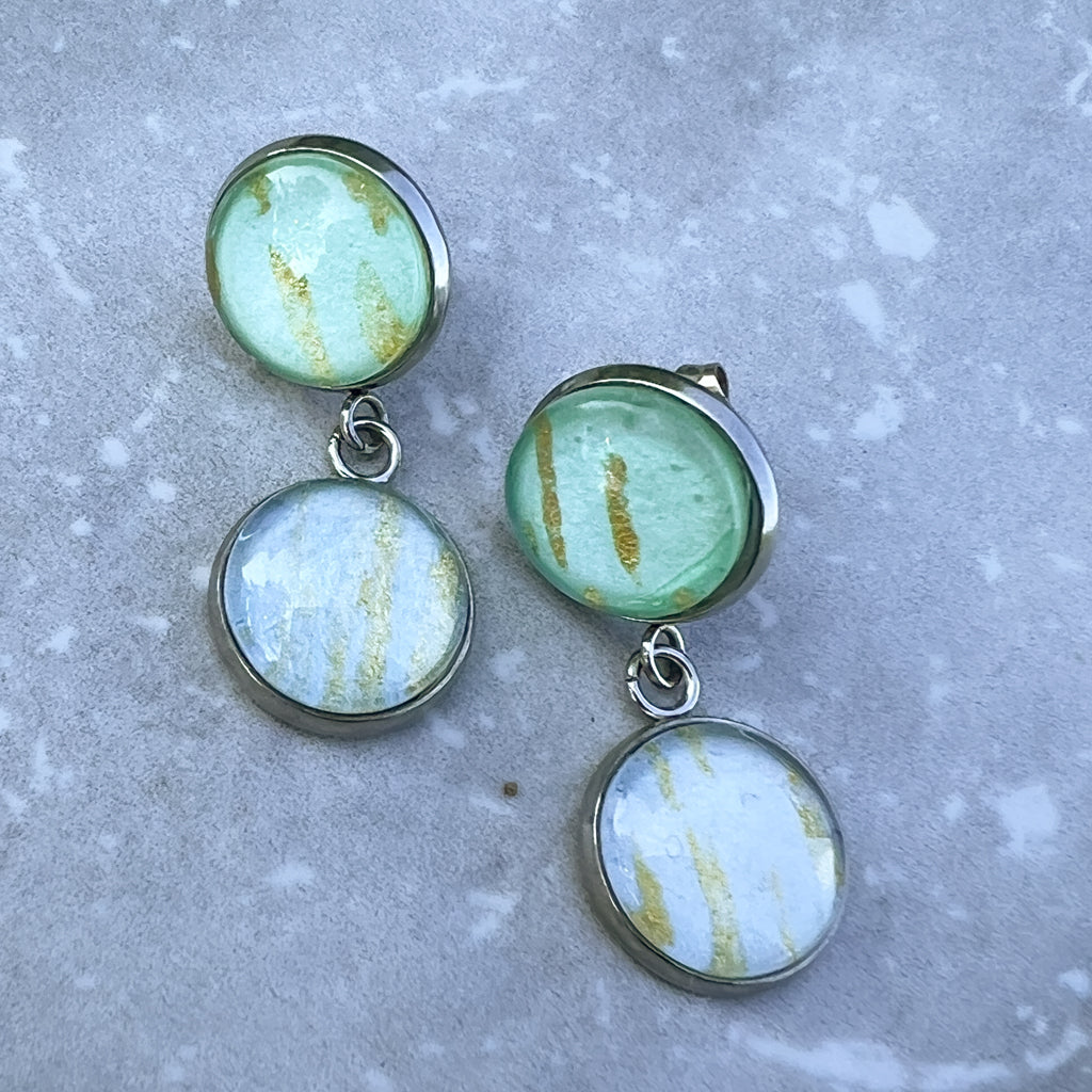 Phobe earrings showing the pale blue and green watercolor art streaked with gold mica. 