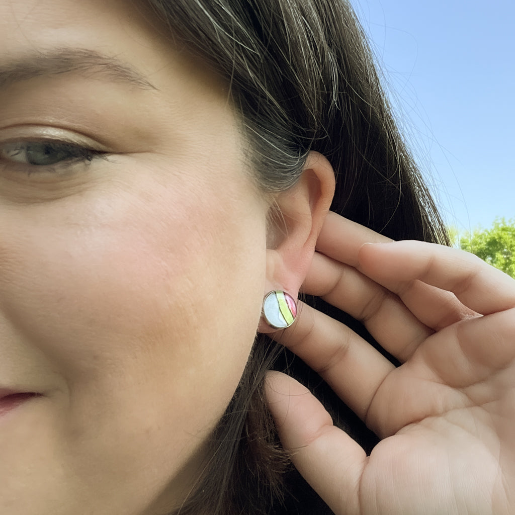 Closeup of rainbow studs showing the hand-painted watercolor and ink detail. 