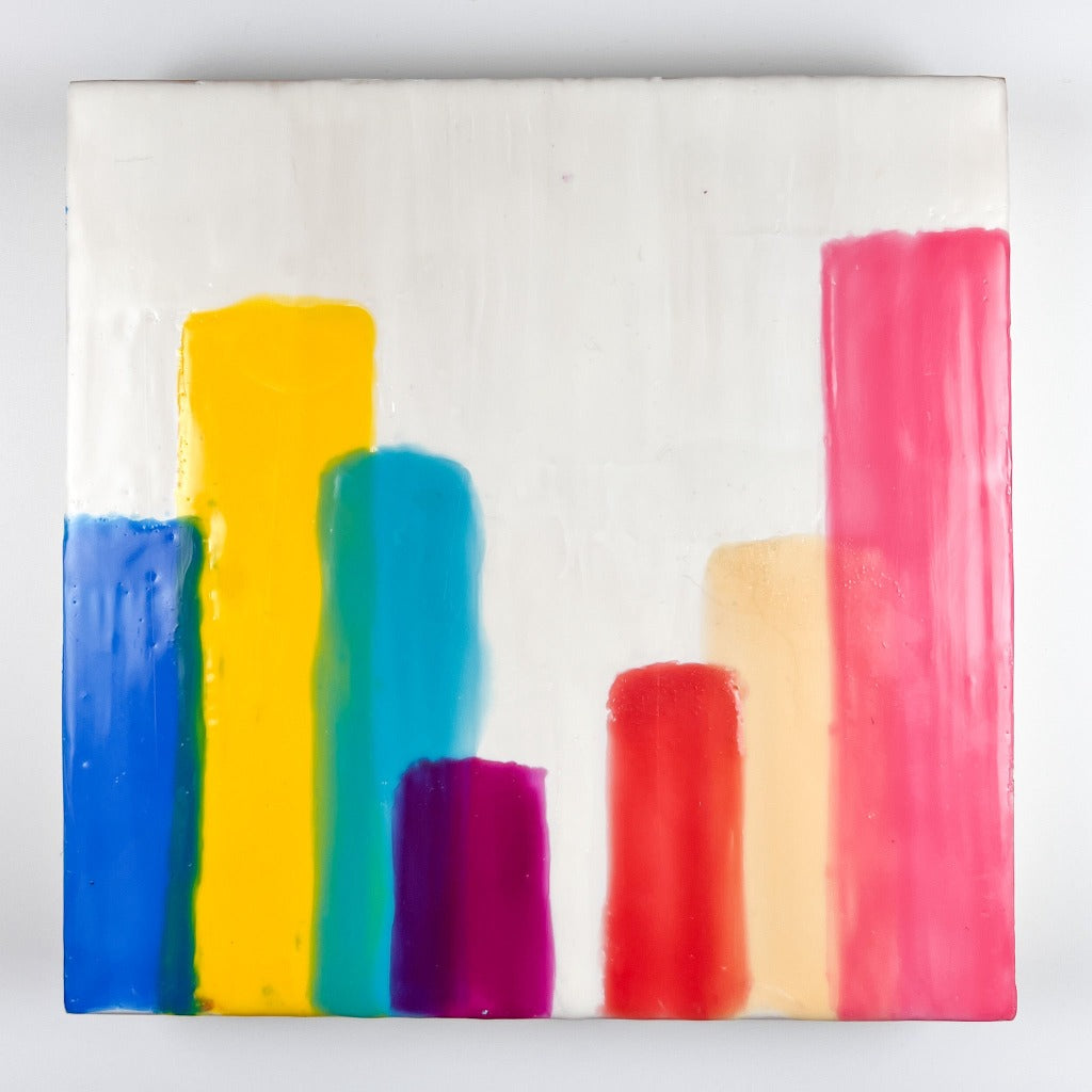 10" by 10" encaustic painting featuring vertical striped of paint on a white background layered to resemlble the buildings in a skyline. 