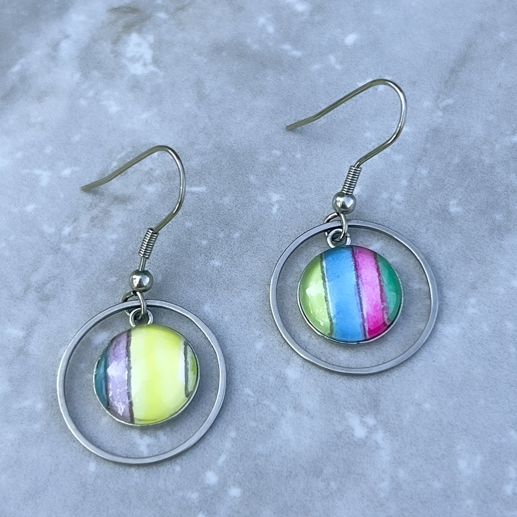Multi-colored watercolor earrings with bright colors and a round frame. 