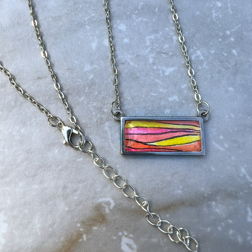 Detail of sunset necklace featuring adjustable chain and lobster clasp. 