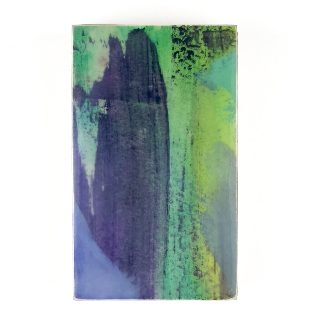 Front view of watercolor and encaustic painting, featuring layered shades of blue, purple and green.