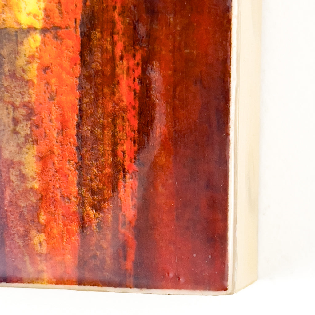 Front view of watercolor and encaustic painting, featuring layered shades of orange, yellow and red.. 