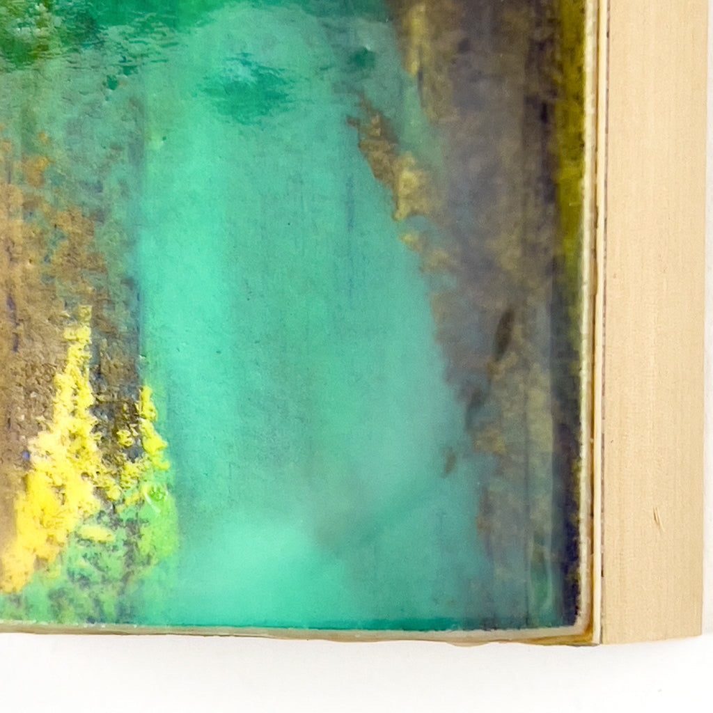 Detail view of watercolor and encaustic painting, featuring layered shades of yellow, green and purple.. 