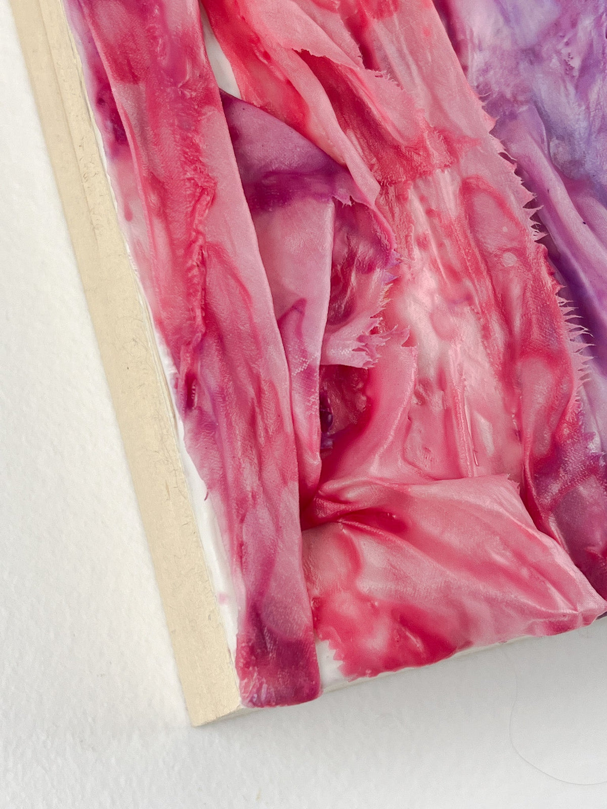 Closeup of encaustic and ribbon art showing edge of cradled birch board.