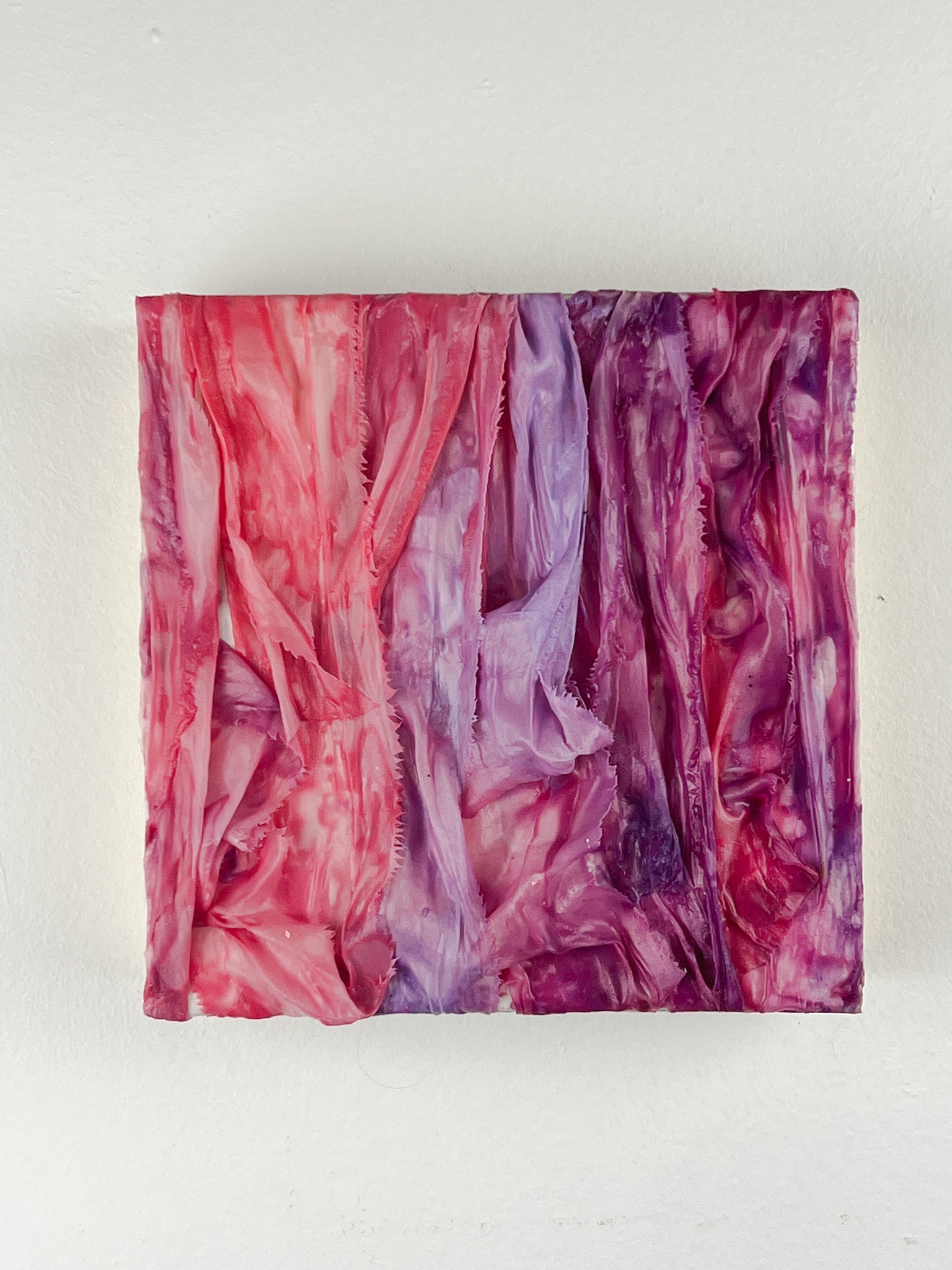 6-inch square encaustic and fiber art featuring ribbons dipped in pink and purple wax and draped.