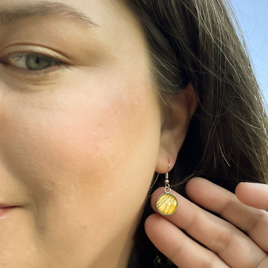 Blan and Gold Tiger Stripe drop earrings shown on grey background. 