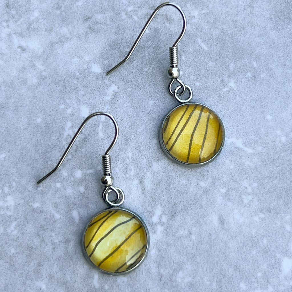 Blan and Gold Tiger Stripe drop earrings shown on grey background. 