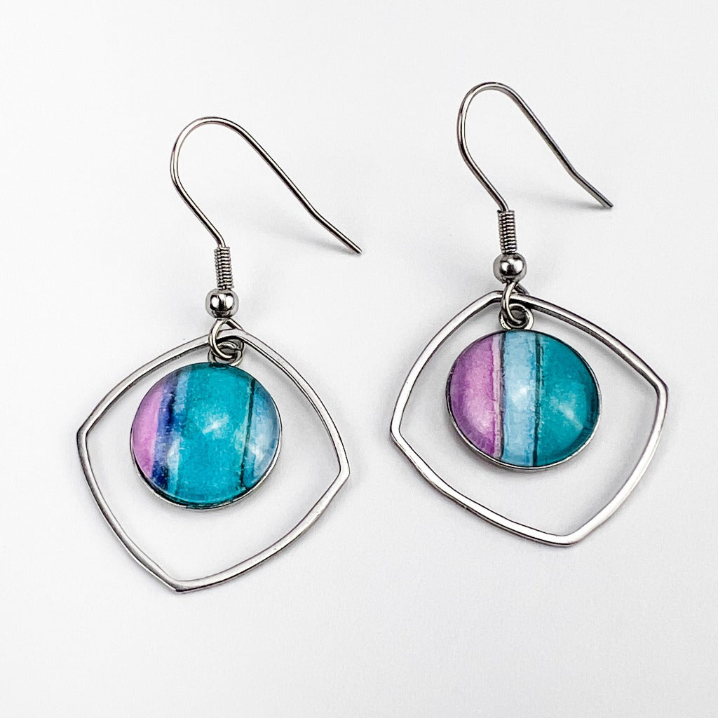 Water Iris 12mm drop earrings made of stainless steel bezels with watercolor art protected behind glass cabochons. Shown on grey background.