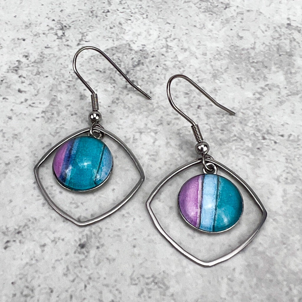 Water Iris 12mm drop earrings made of stainless steel bezels with watercolor art protected behind glass cabochons. Shown on grey background.