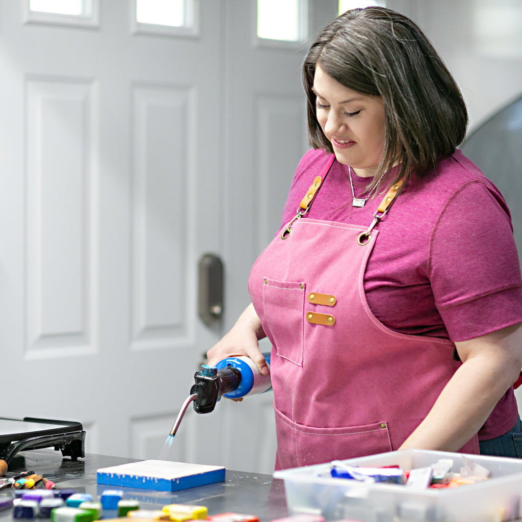 Jamie Scheppers in her studio fusing an encaustic painting with a propane torch.